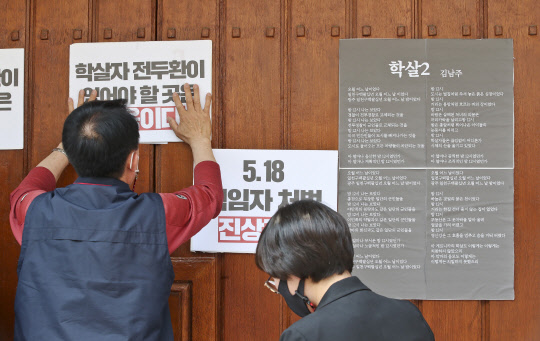 제41주년 5·18 민주화운동 기념일인 지난달 18일 오후 서울 서대문구 연희동 전두환 전 대통령 자택 앞에서 진보당 서대문구위원회, 서대문겨레하나 등 서대문구 지역 시민사회단체 관계자들이 김남주 시인의 시 '학살2'와 규탄 피켓을 부착하고 있다. <연합뉴스>